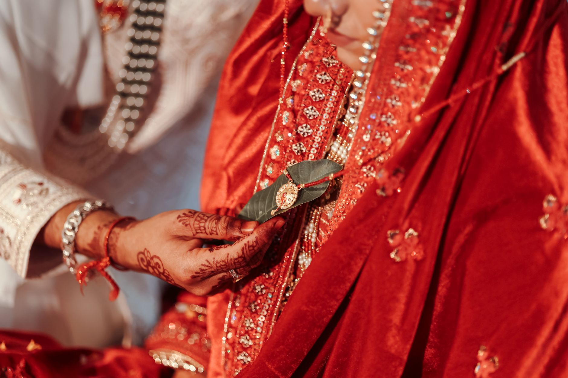 Close-up of a ceremonial ritual during a traditional Indian wedding in vibrant attire.