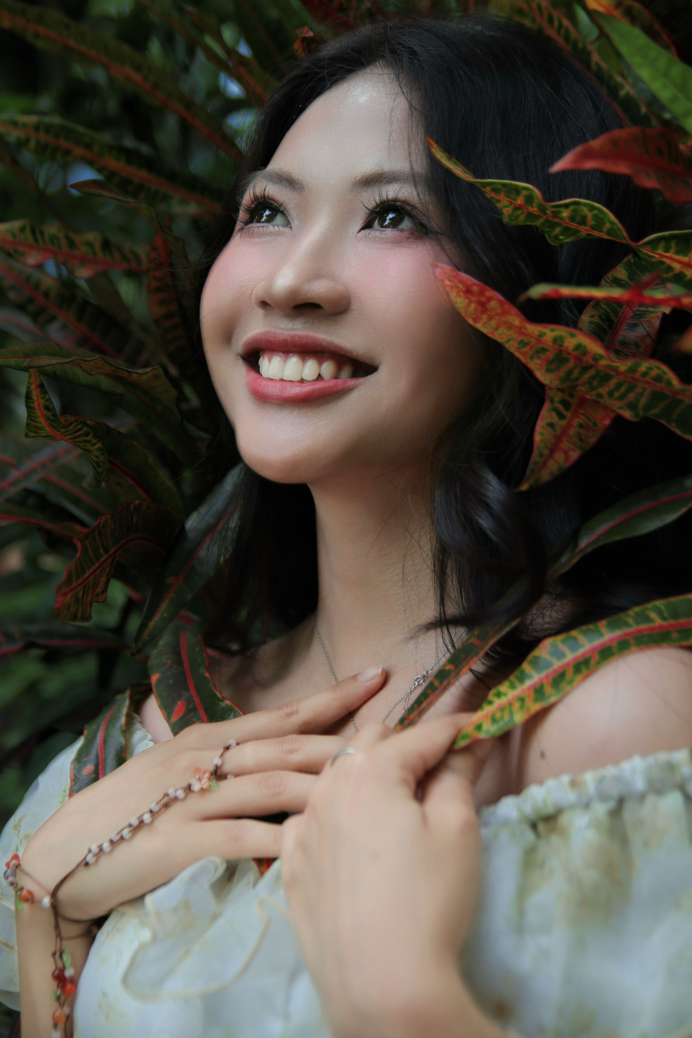 Smiling Woman with Tropical Leaves Outdoors
