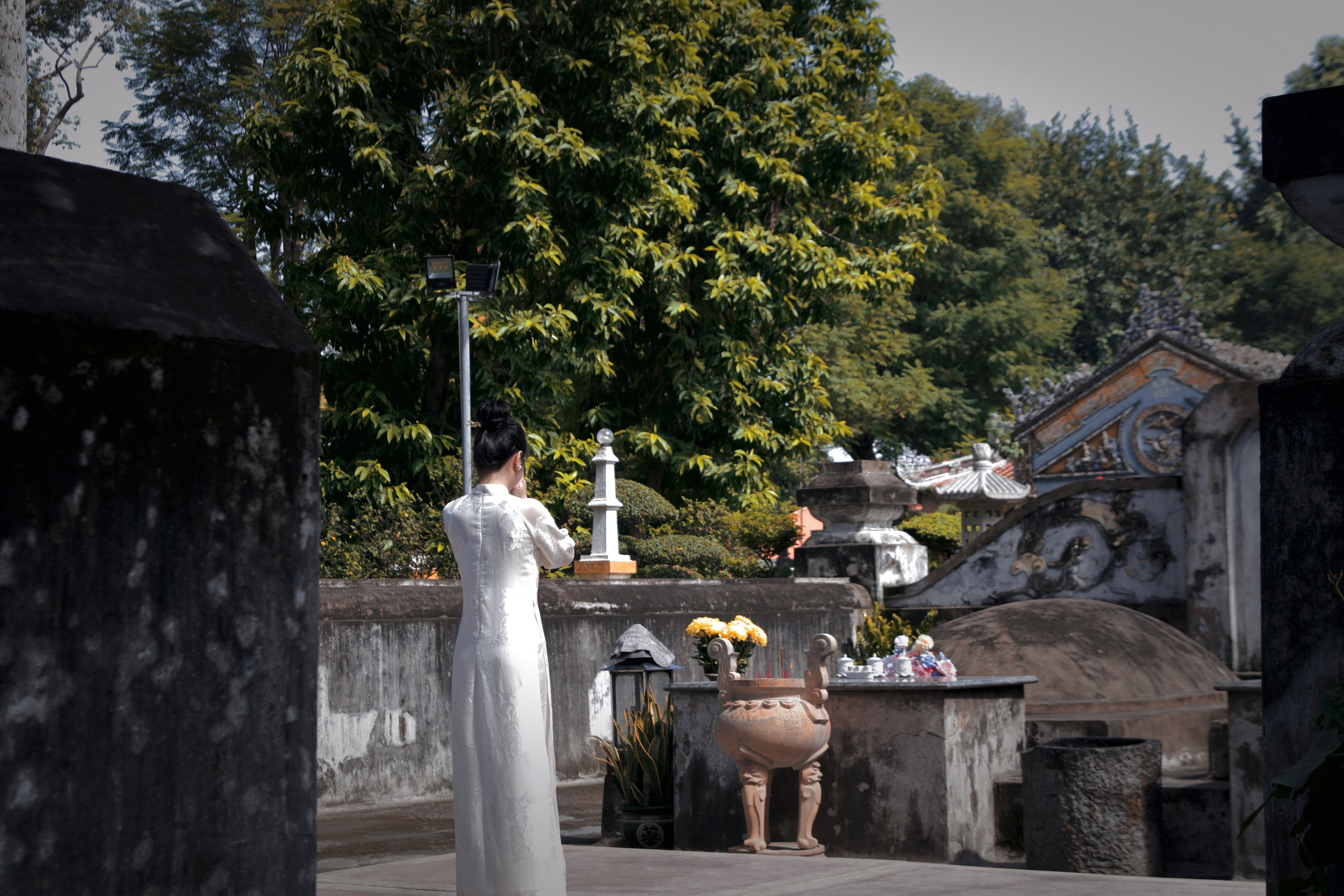 Woman in Traditional Dress at a Cemetery Ritual · Free Stock Photo