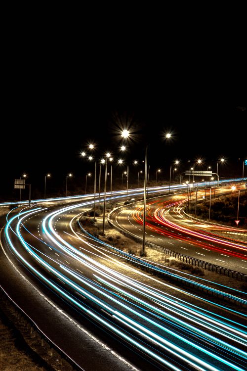 Free Capture of vibrant light trails on a highway at night, showing motion and speed. Stock Photo
