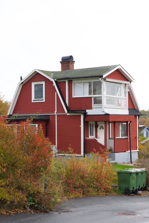 Free Charming red wooden house surrounded by autumn foliage in Huskvarna, Sweden. Stock Photo