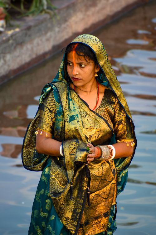 Free Traditional Indian woman wearing saree near river, reflecting cultural heritage. Stock Photo