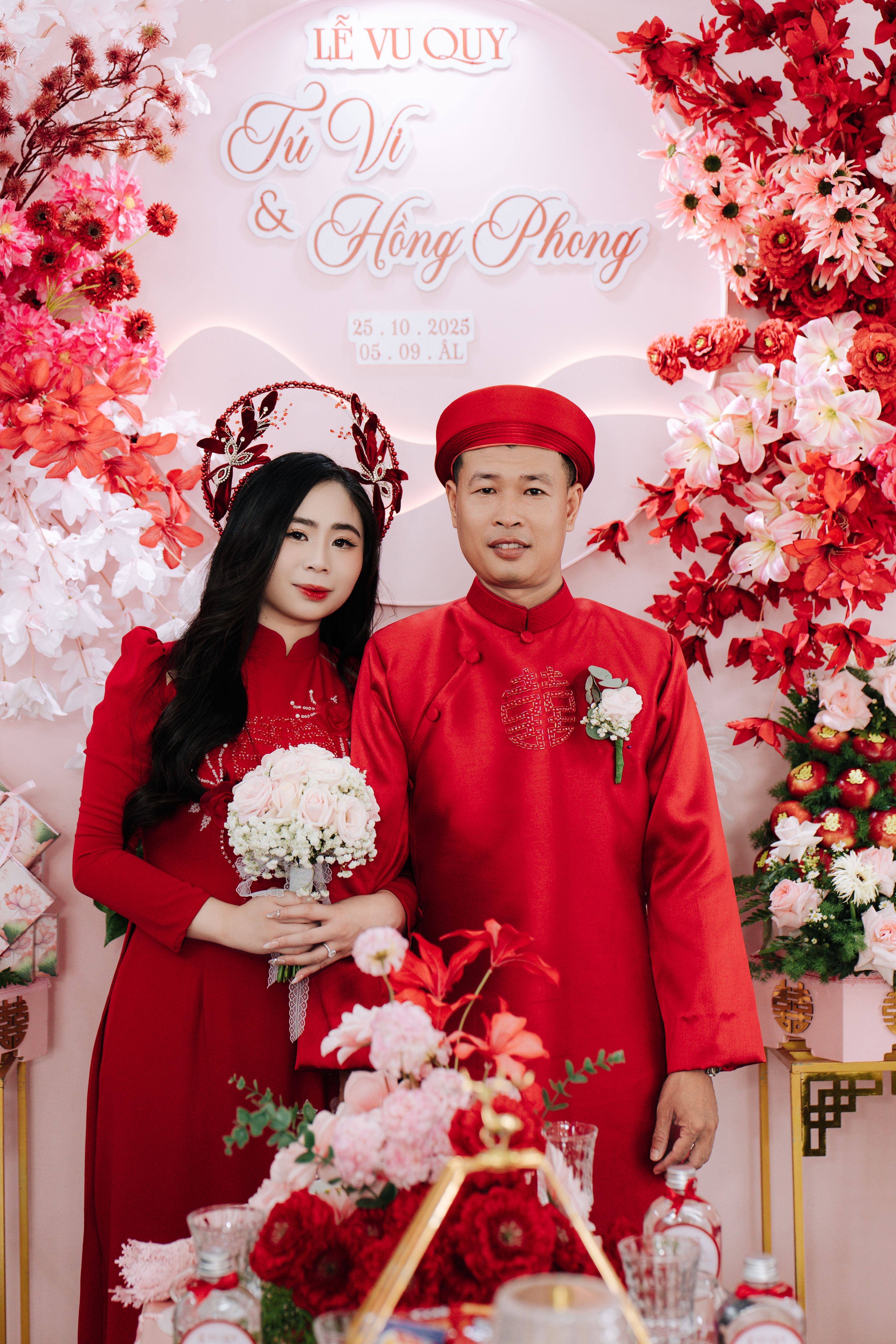 A couple in traditional red attire during a Vietnamese wedding ceremony.
