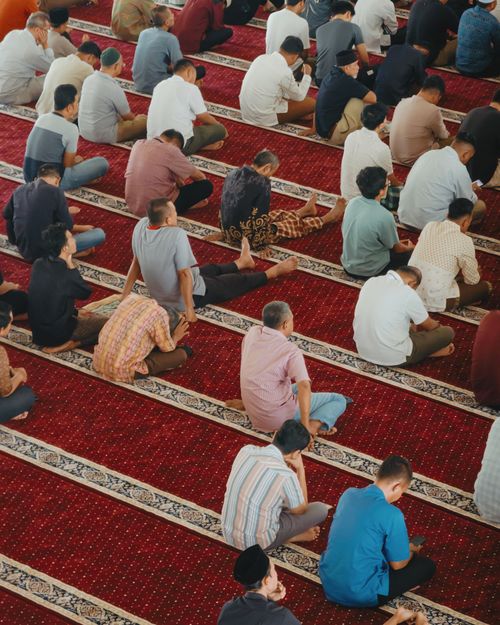 Free Overhead view of people praying inside a mosque in Indonesia, showcasing Islamic culture. Stock Photo