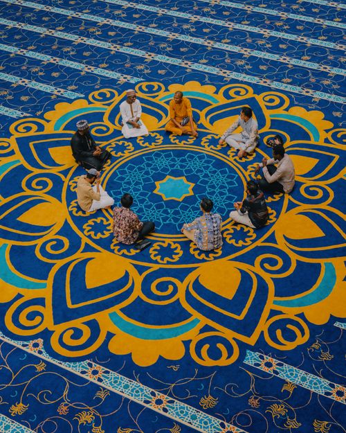Free A group of men meditating in a beautifully adorned mosque in Indonesia, showcasing intricate designs. Stock Photo