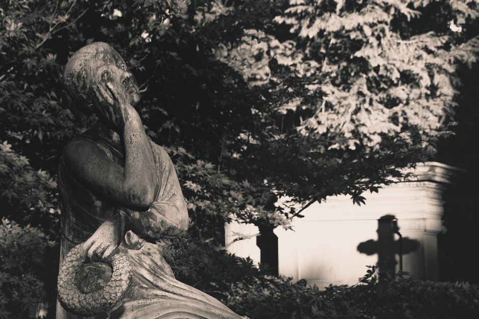 Fotomural Una estatua de cementerio pacífica que se relaja bajo una iluminación monocromática tenue.