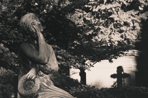 Free A peaceful cemetery statue basking in moody monochrome lighting. Stock Photo