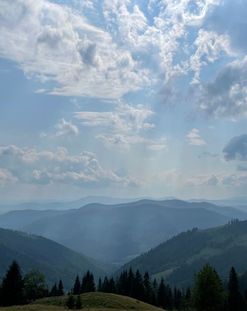 Free Scenic view of layered mountains and cloudy sky, casting soft light over the peaceful landscape. Stock Photo