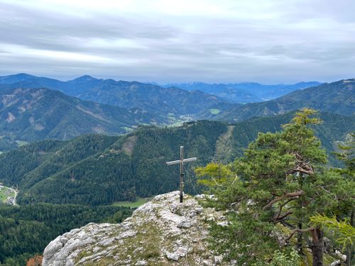 Free Explore the breathtaking view of Mixnitz mountains featuring a summit cross and lush forests. Stock Photo