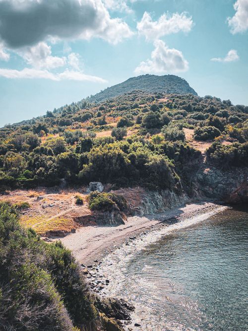 Free A peaceful view of Toroni's coastline in Greece with lush hills and tranquil waters. Stock Photo