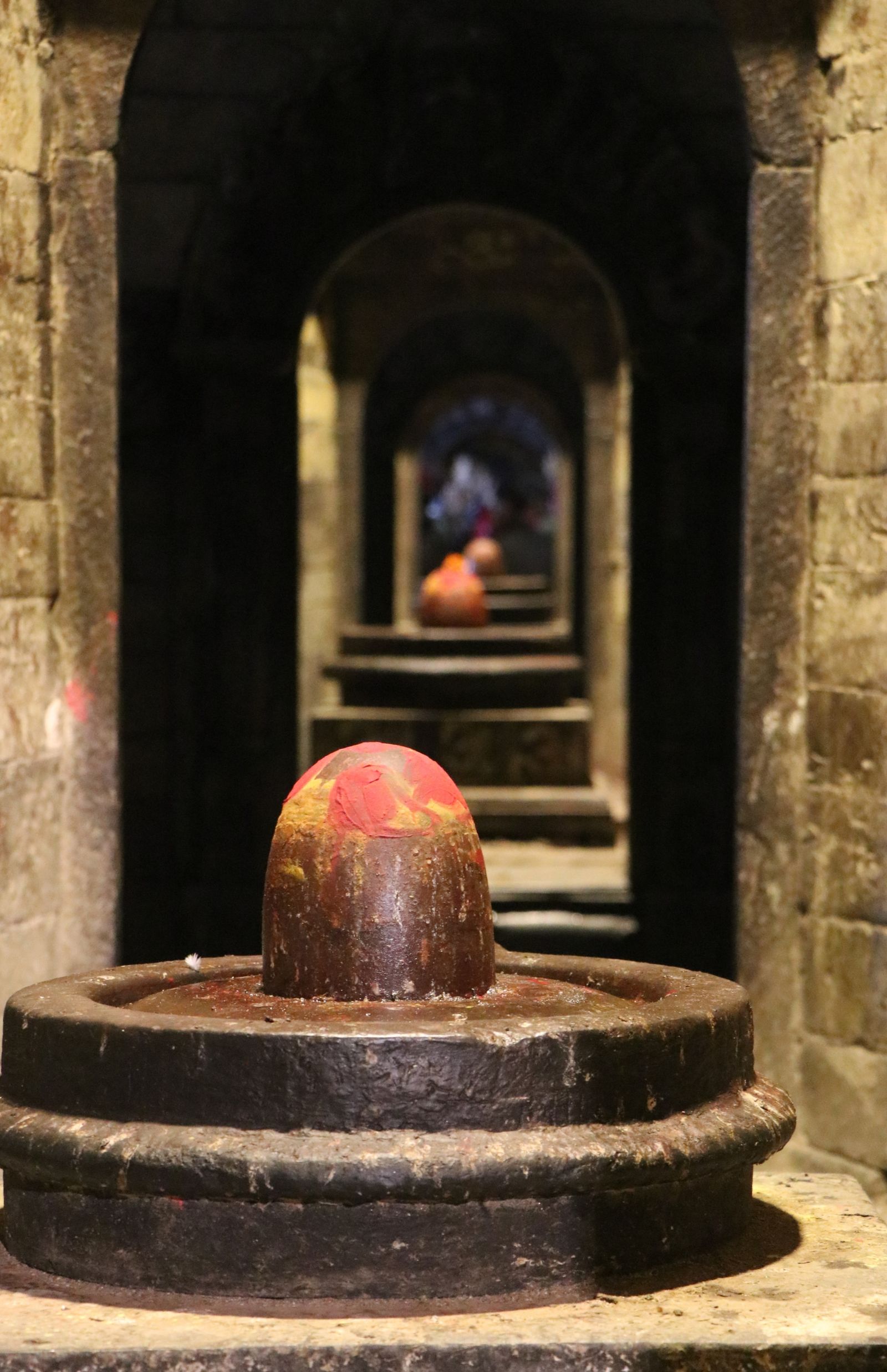 Shiva lingams set one behind another through a row of arched stone shrines at Pashupatinath in Kathmandu