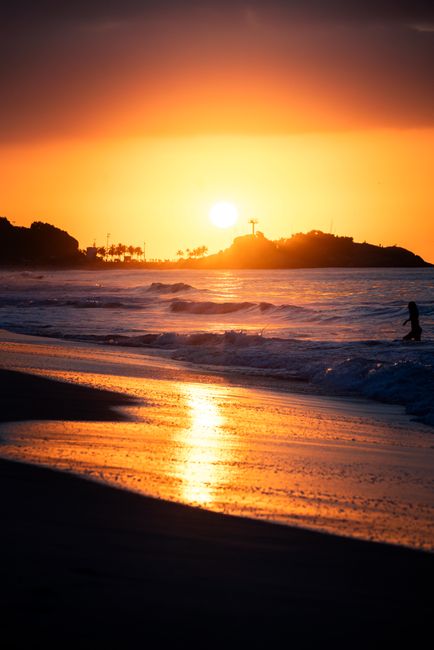 Breathtaking beach sunset casting vibrant reflections on waves.