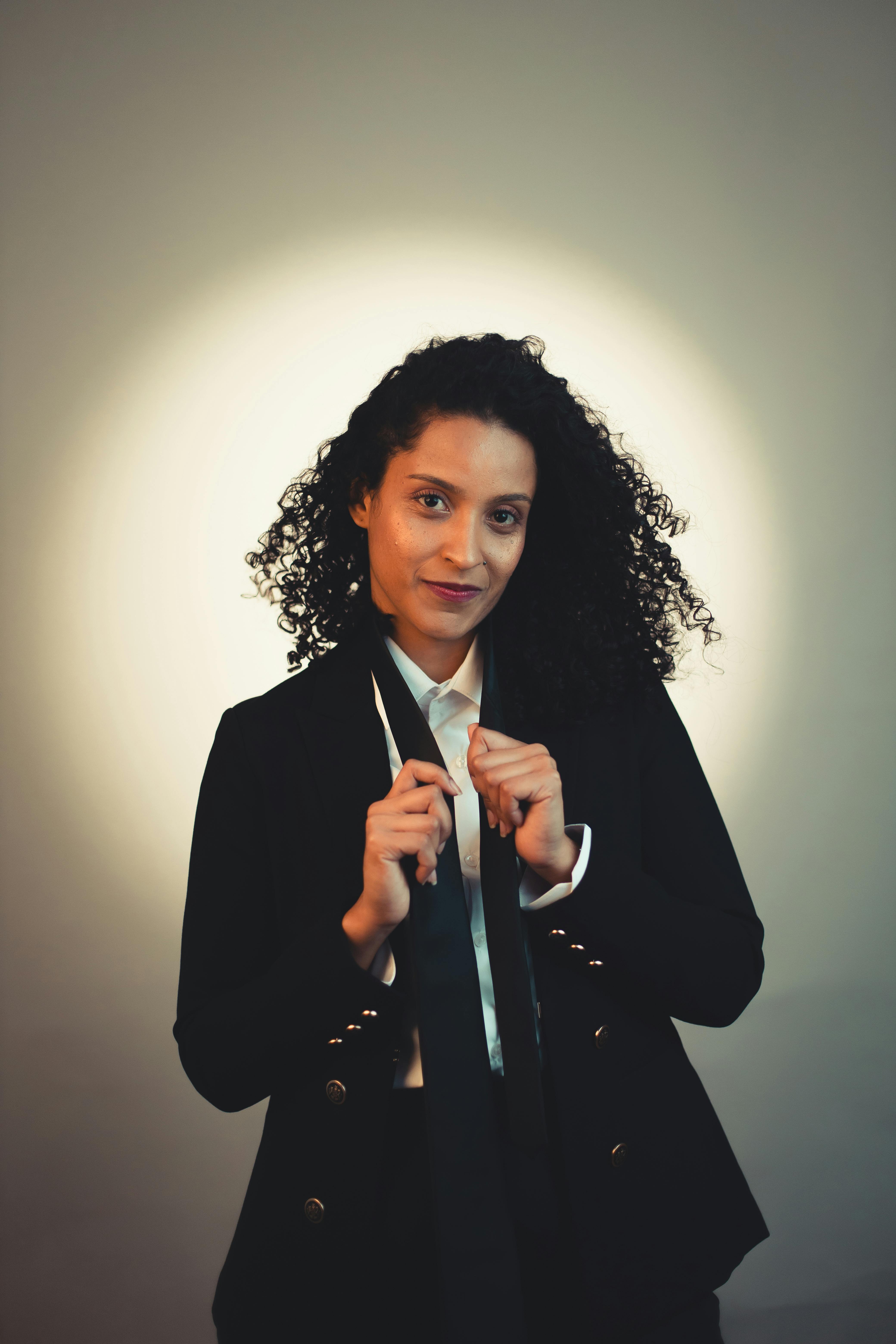 gratis Portret van een zelfverzekerde vrouw in zakelijke kleding met een spotlighteffect. Stockfoto