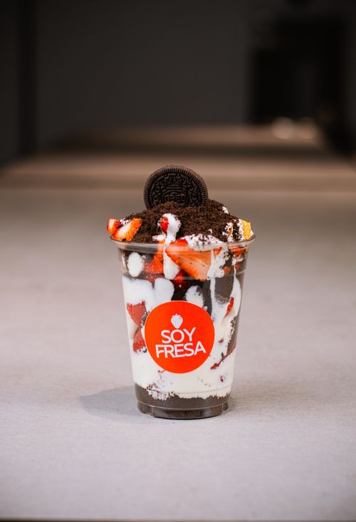 Free Cup of creamy dessert with strawberries and Oreo, highlighted by Soy Fresa branding on the cup. Stock Photo