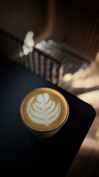 Captivating latte with intricate art design in a cozy café setting. Perfect for coffee lovers.