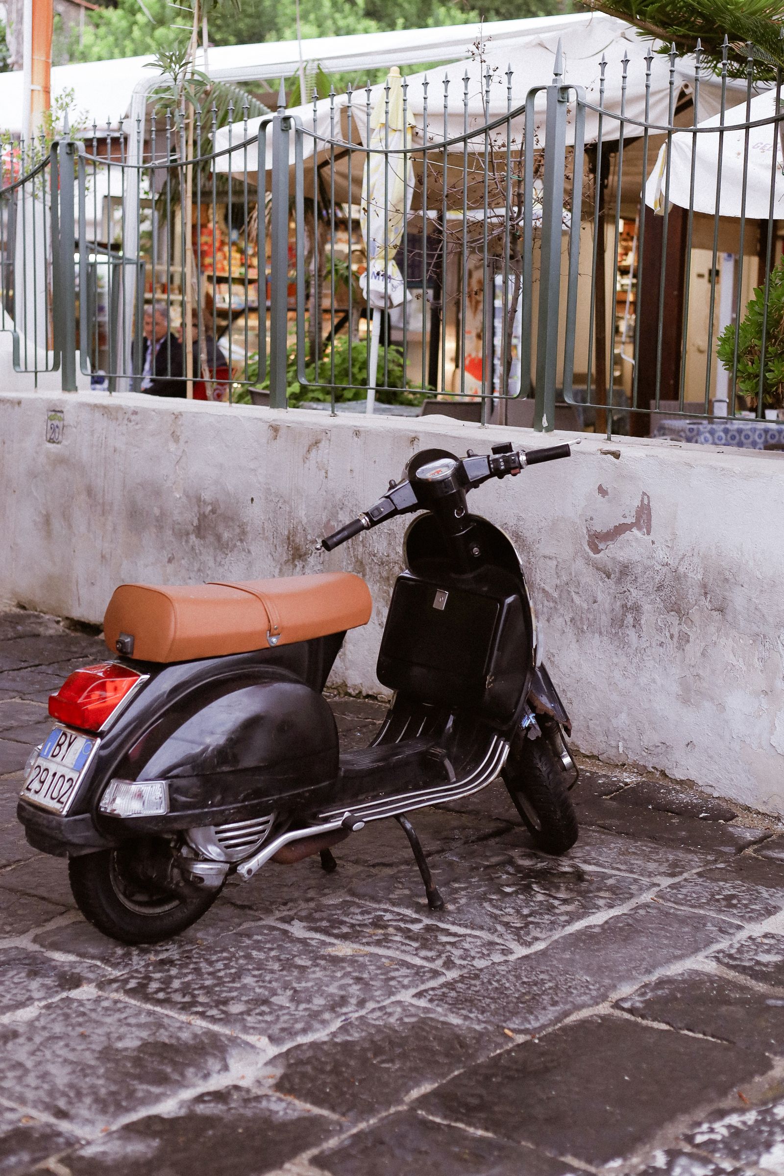 A classic Vespa scooter parked on a cobblestone European street