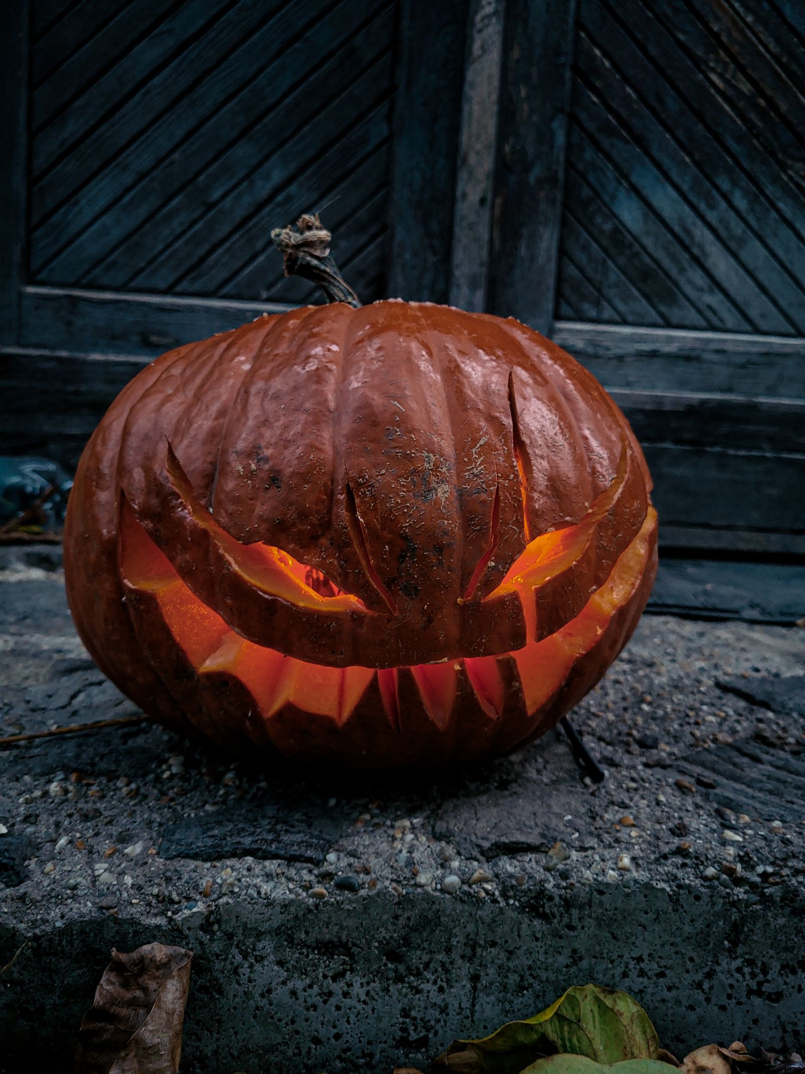 Glowing carved Halloween pumpkin outside at night