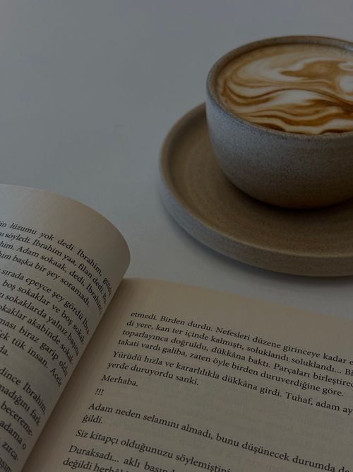 Free Warm coffee cup with a book, perfect for a relaxing reading session. Stock Photo