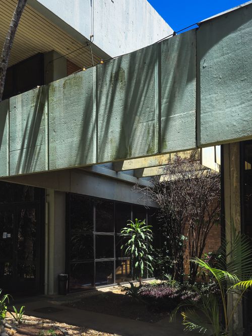 Free Sunlit architectural exterior showcasing modern concrete design with greenery. Stock Photo