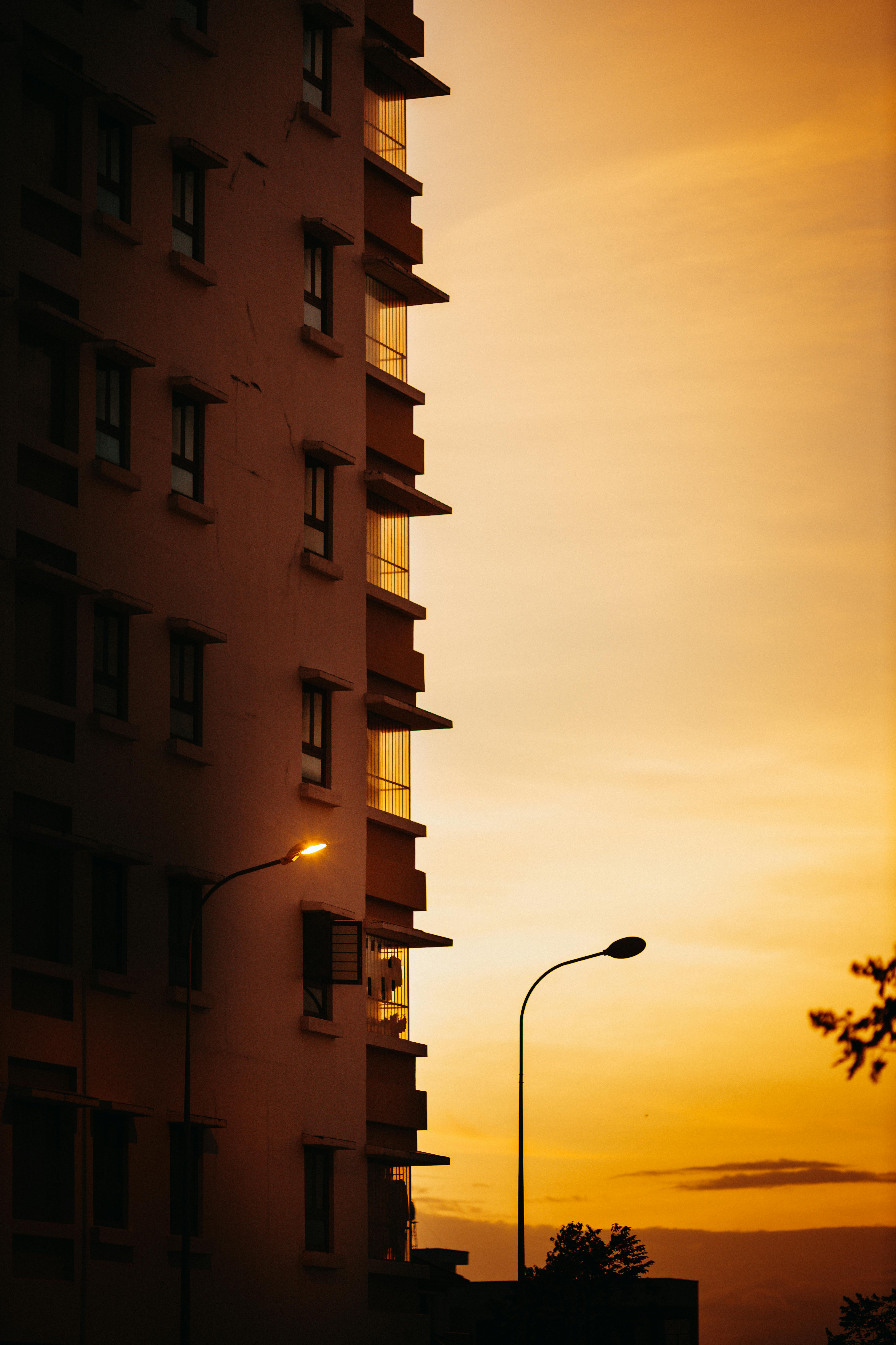 Gratuit O priveliște uimitoare a unei clădiri pe fundalul unui apus de soare viu în Kon Tum, Vietnam, prezentând un cadru urban. Fotografie de stoc