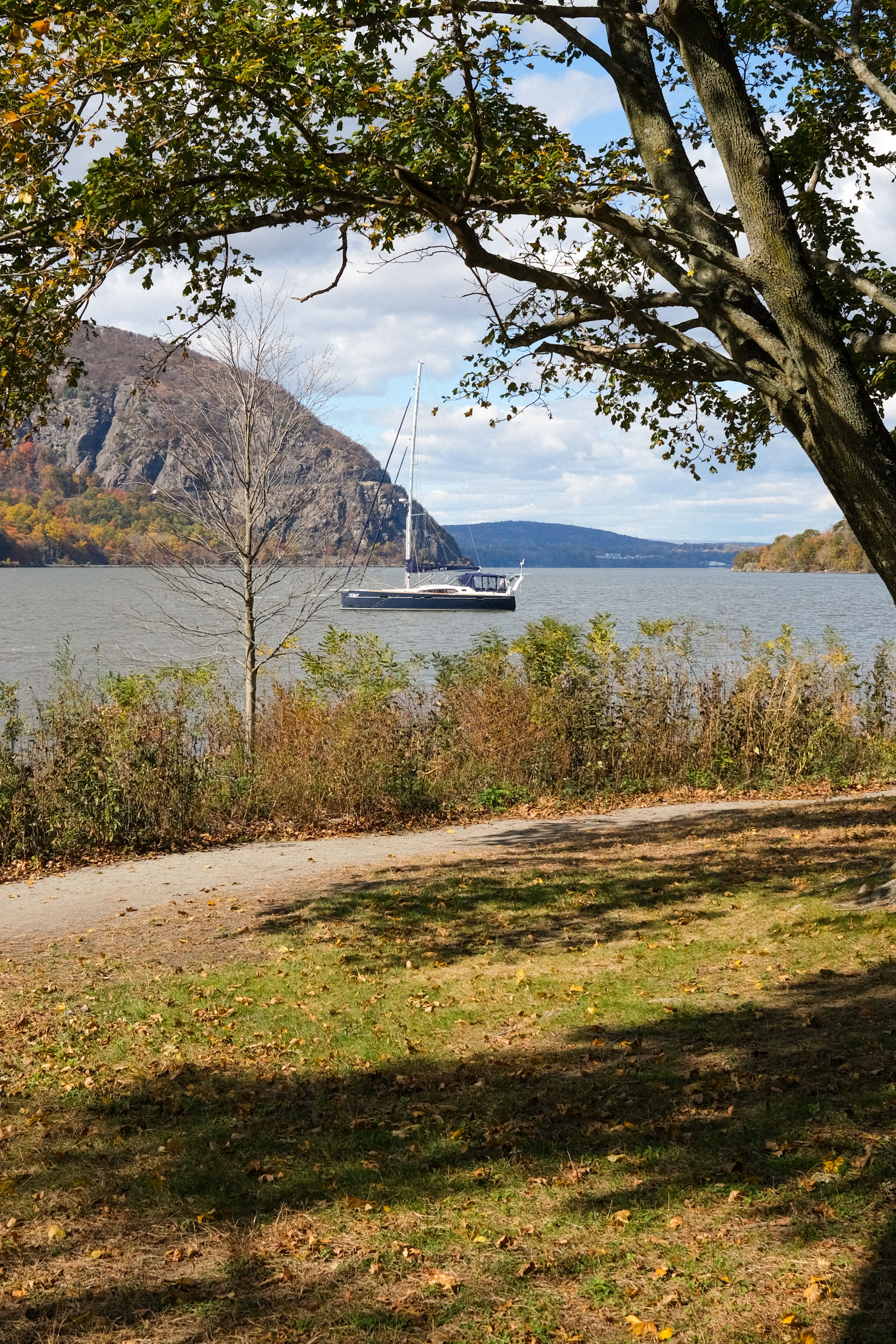 Serene autumn Hudson River scene with sailboat