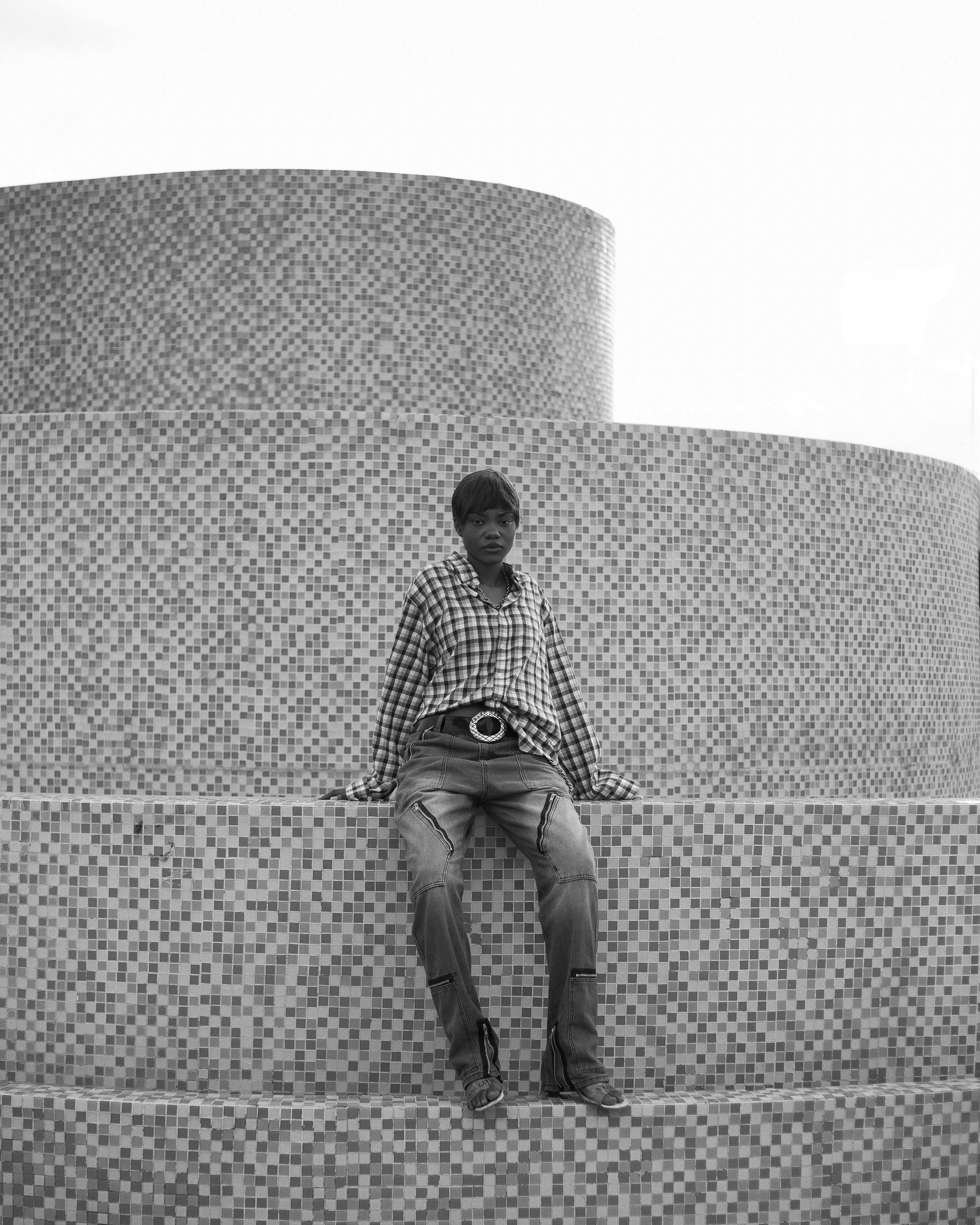 Free Black and white photo of a man on a mosaic staircase with circular patterns. Stock Photo
