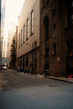 A quiet urban alleyway with brick buildings and soft sunlight filtering through, evoking a serene cityscape.