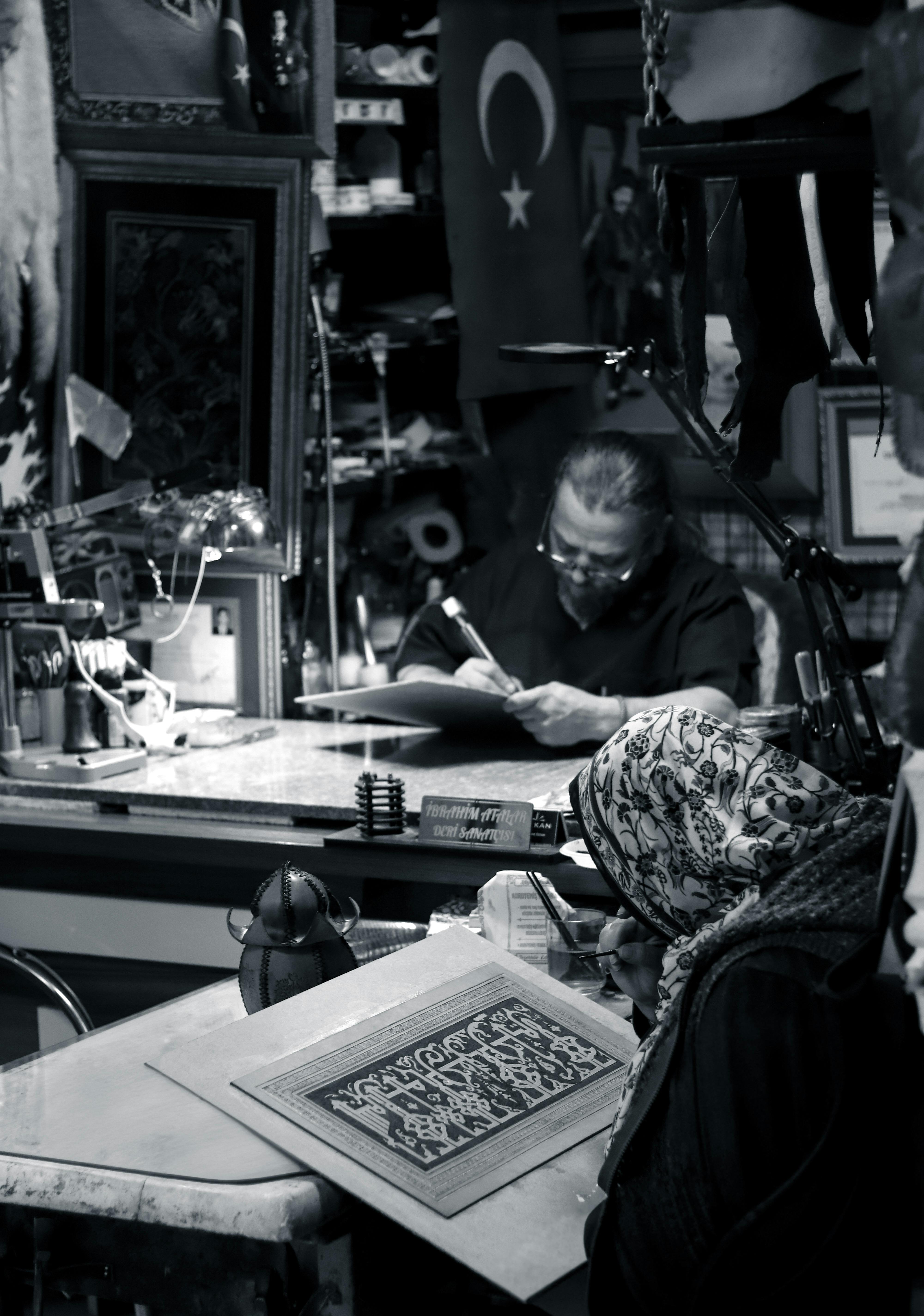 Two artists focus on crafting intricate designs in a workshop with Turkish decor, rich in culture and tradition.