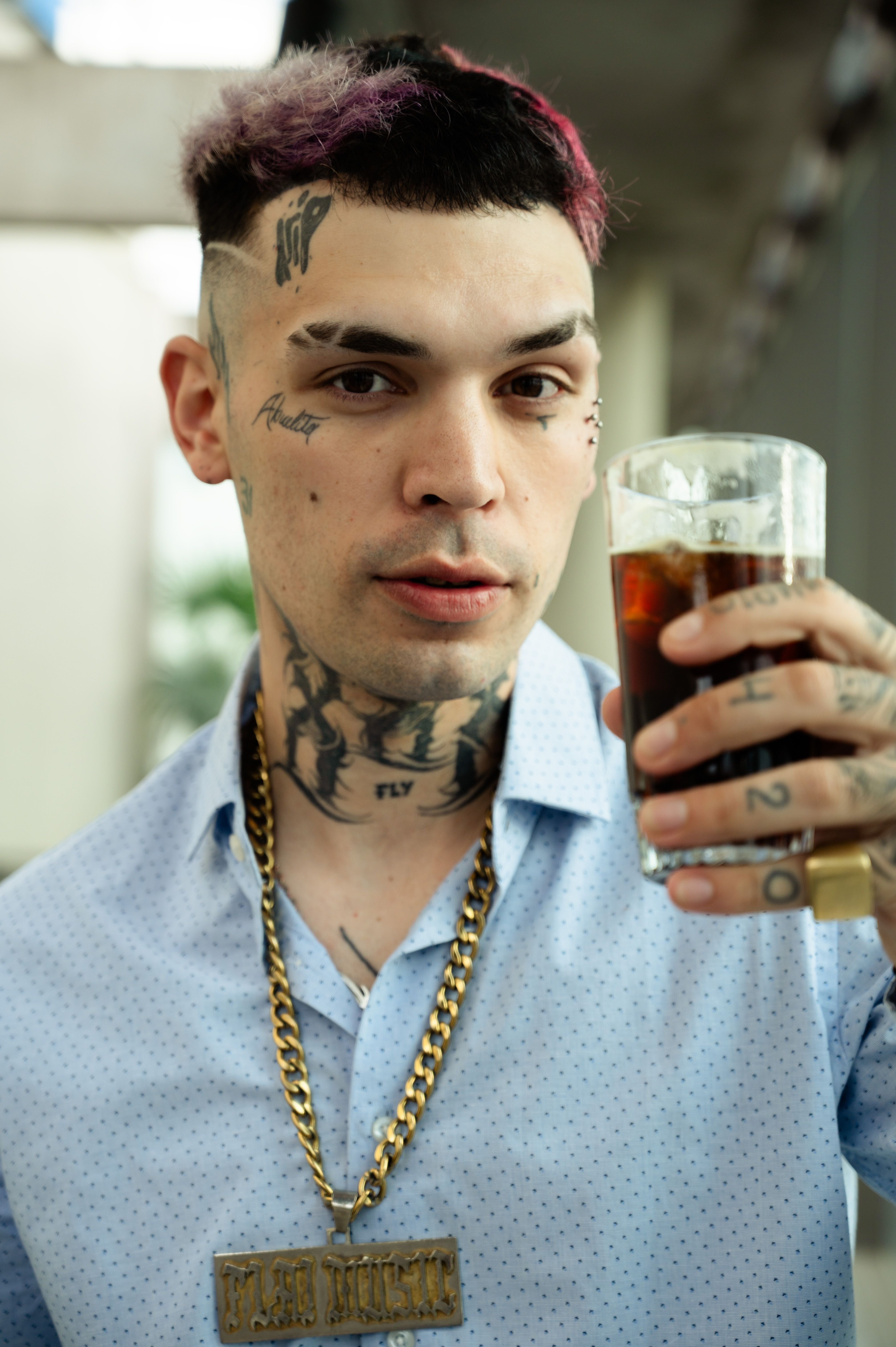 Portrait of a modern man with tattoos enjoying a drink, set in vibrant Buenos Aires atmosphere.
