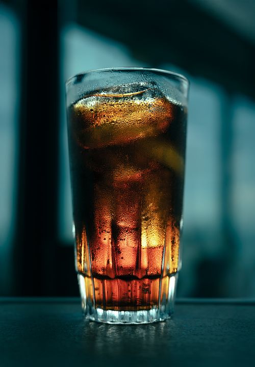 Free Chilled glass filled with dark refreshing beverage and ice cubes, perfect thirst-quencher. Stock Photo