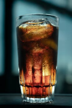 Close-up of a chilled beverage with ice cubes, captured during sunset for a refreshing look.