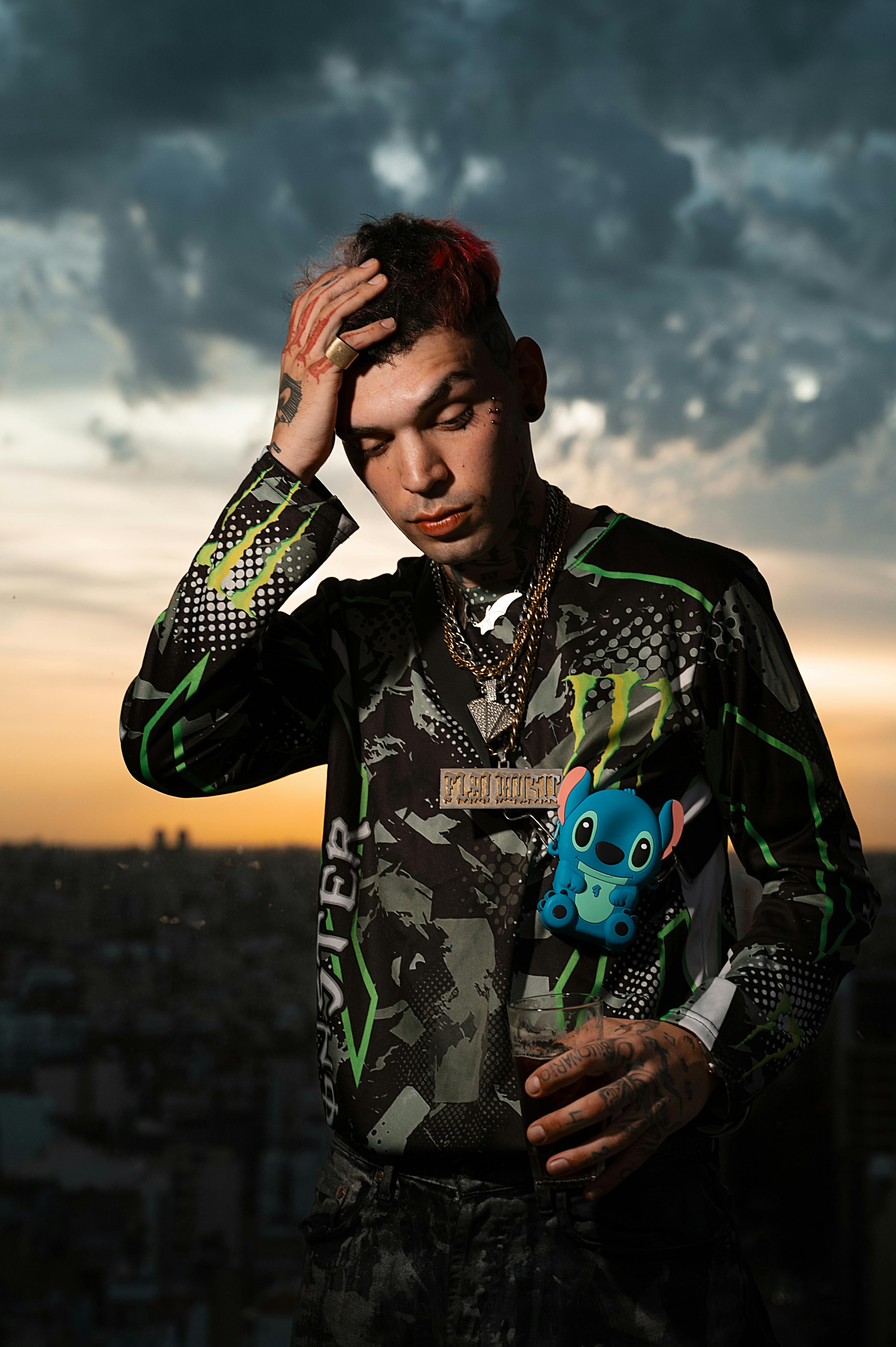 Portrait of a stylish man posing at sunset with dramatic clouds over Buenos Aires.