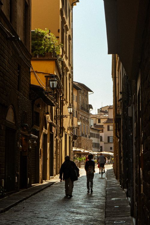 Free Silhouettes on a sunlit street in historic Florence, Italy. Captivating architectural details. Stock Photo