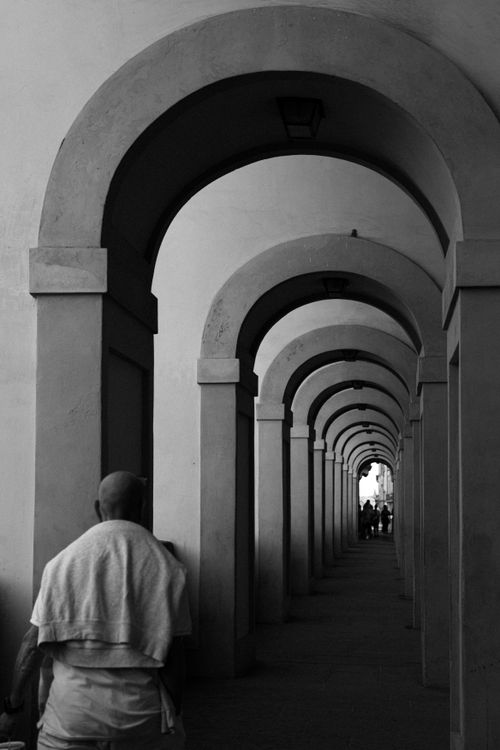 Free A striking black and white photo of an arched corridor in Florence, Italy, highlighting symmetry and depth. Stock Photo