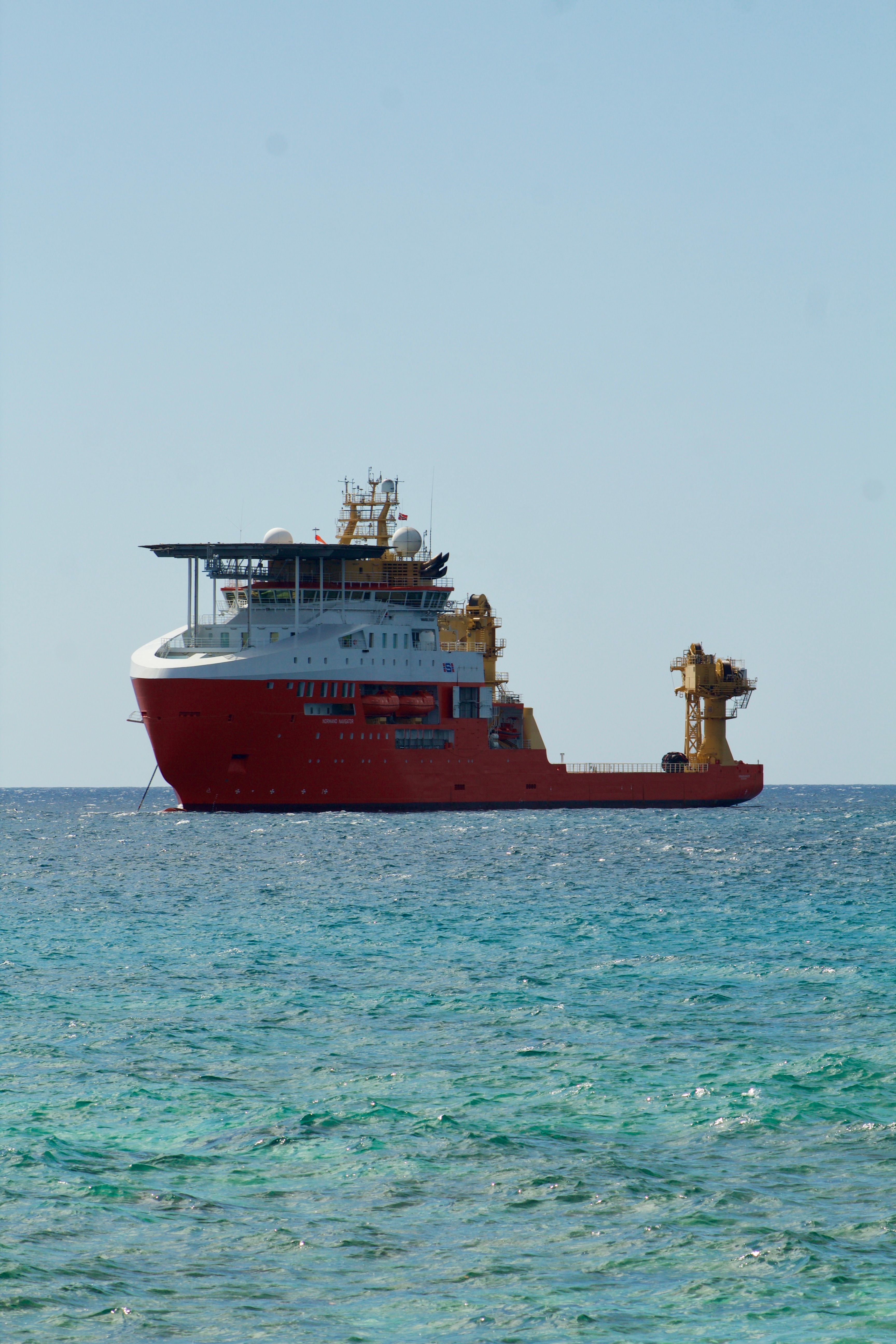 Red Cargo Ship on Blue Ocean Horizon · Free Stock Photo