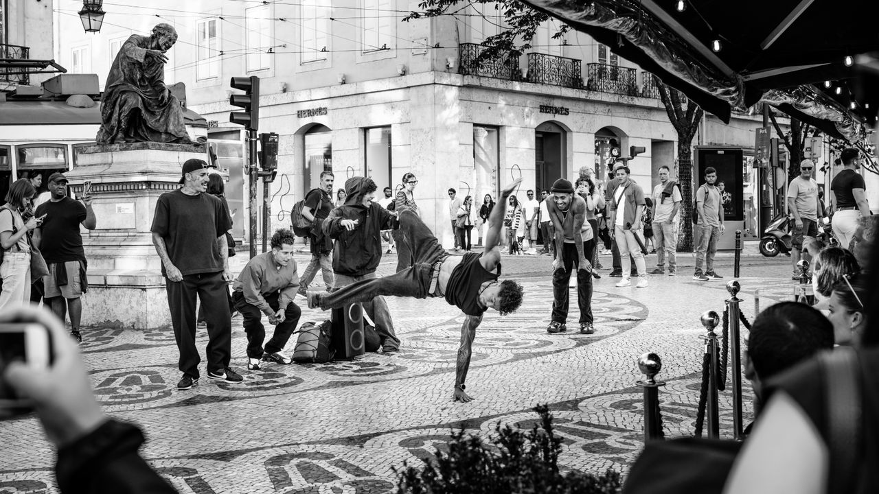 black and white image of street performers in a lively urban scene