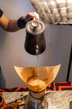 Preparing fresh coffee with a Chemex and kettle pouring over method.