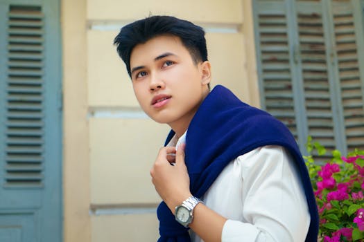 Sophisticated outdoor portrait of a man in classic attire against a vintage backdrop in Ho Chi Minh City.