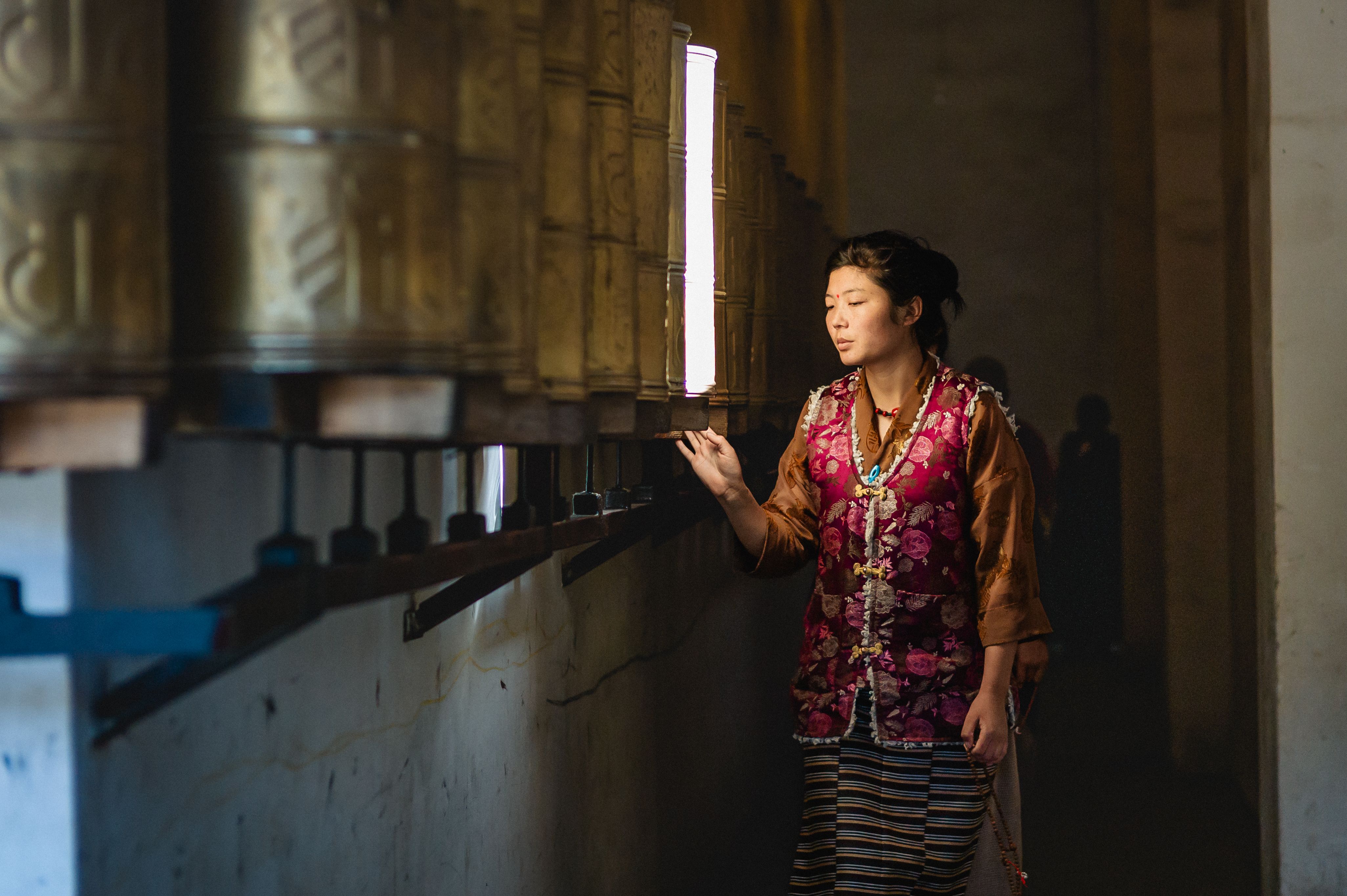 Tibetan three metal bracelet - A Tibetan woman turns prayer wheels inside a temple in Sichuan, China. | Buddhabelief