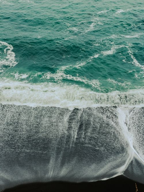 Free A powerful wave crashes onto a rocky shore, capturing the dynamic beauty of the ocean's movement. Stock Photo