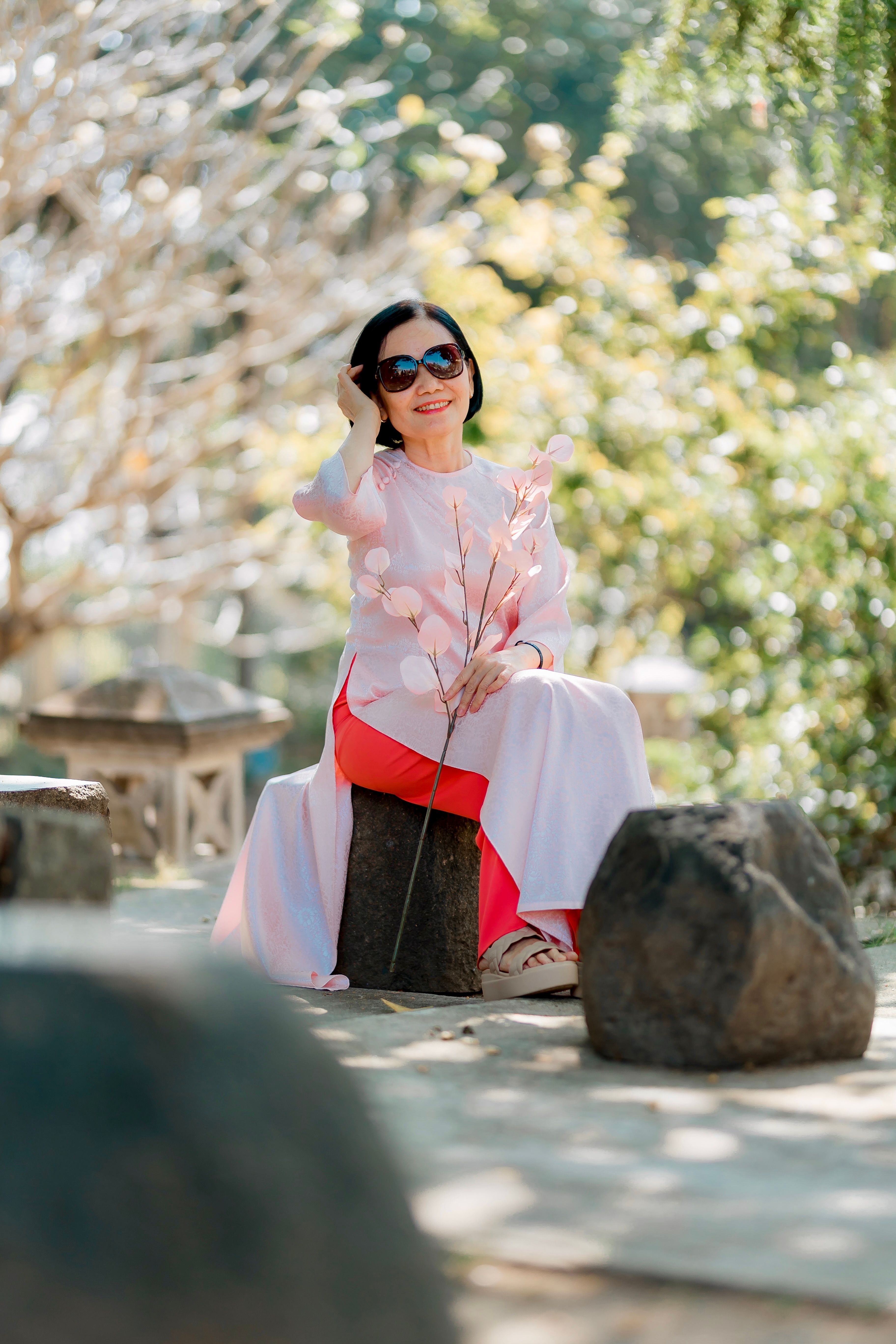 Elegant Woman Sitting Outdoors in Natural Setting · Free Stock Photo