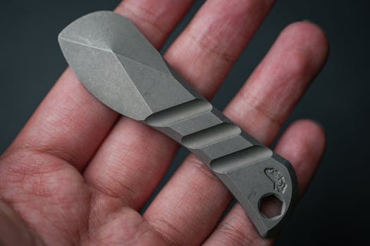 Detailed close-up of a stone-carved tool held in a person's hand.