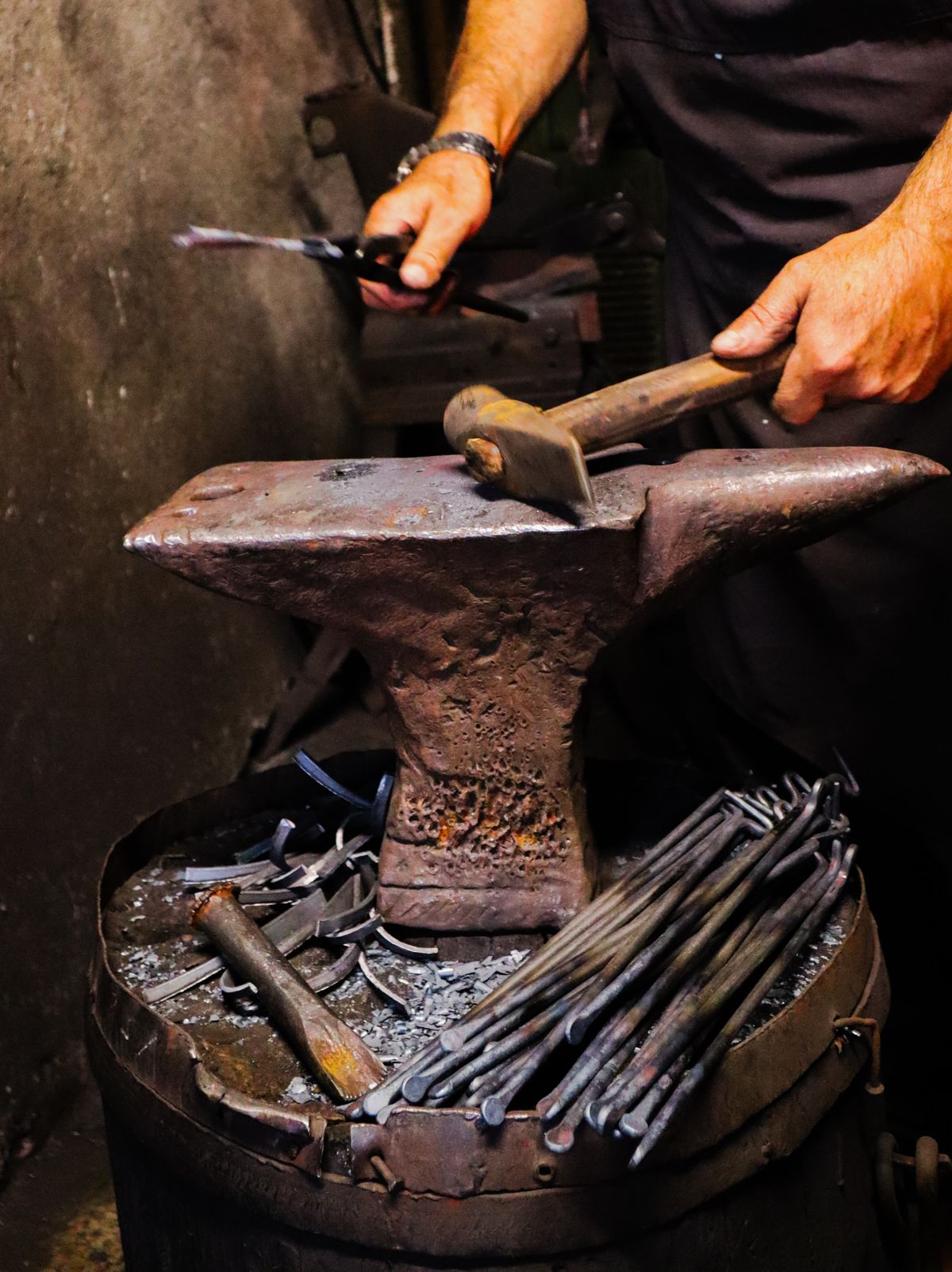 Blacksmith shaping heated iron on an anvil in a traditional forge