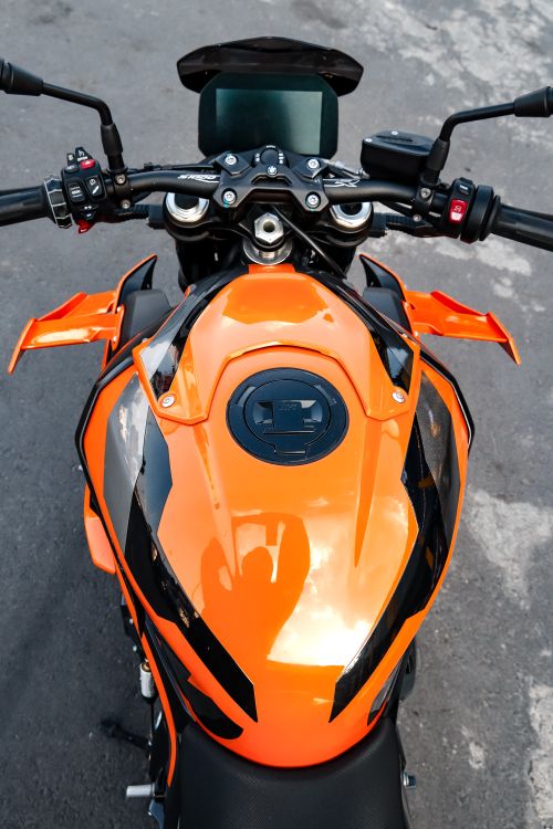 Free High-angle shot of a bright orange motorcycle from above on asphalt. Stock Photo