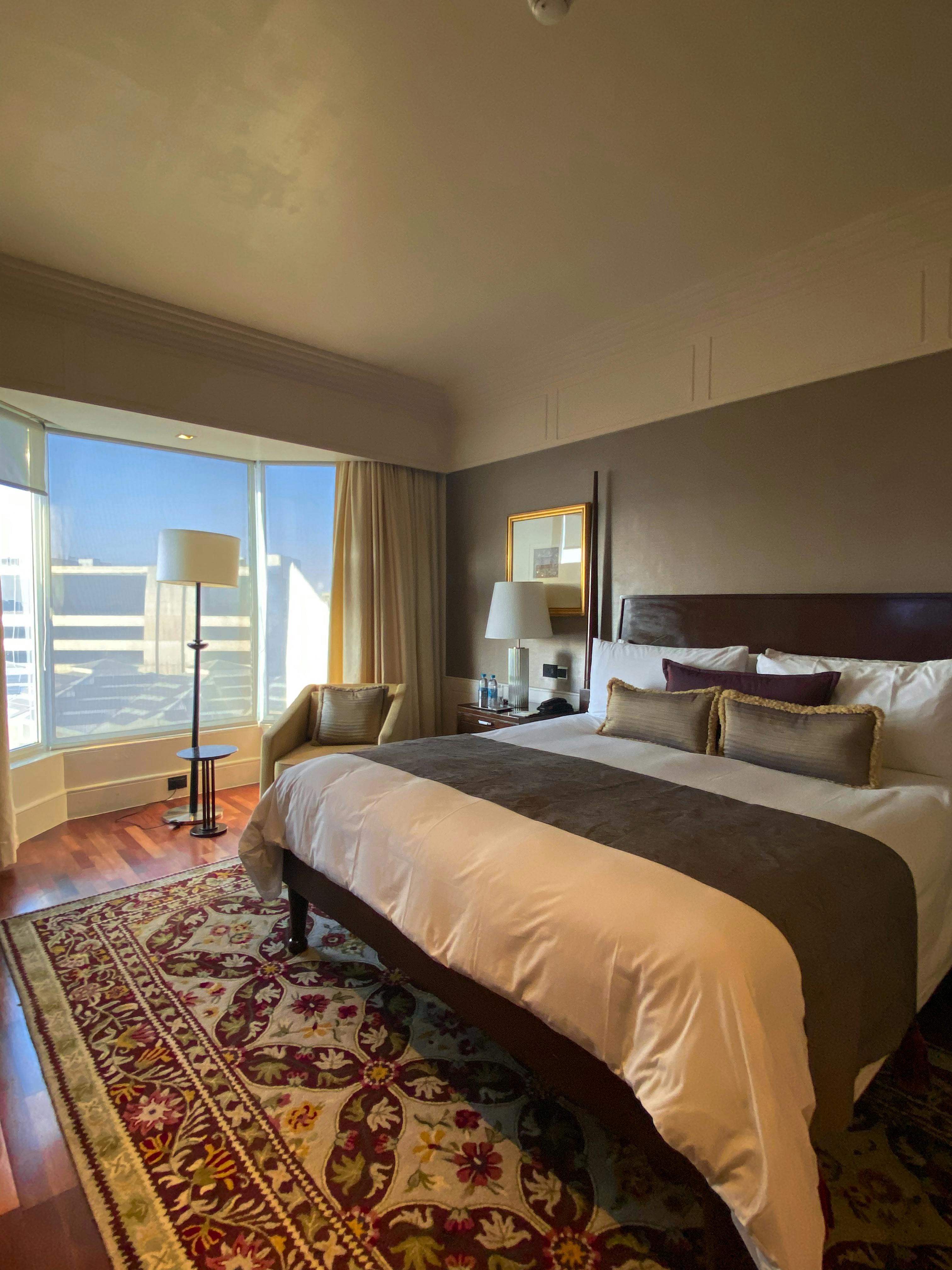 Elegant and spacious boutique hotel room in Mumbai with natural light and chic decor.