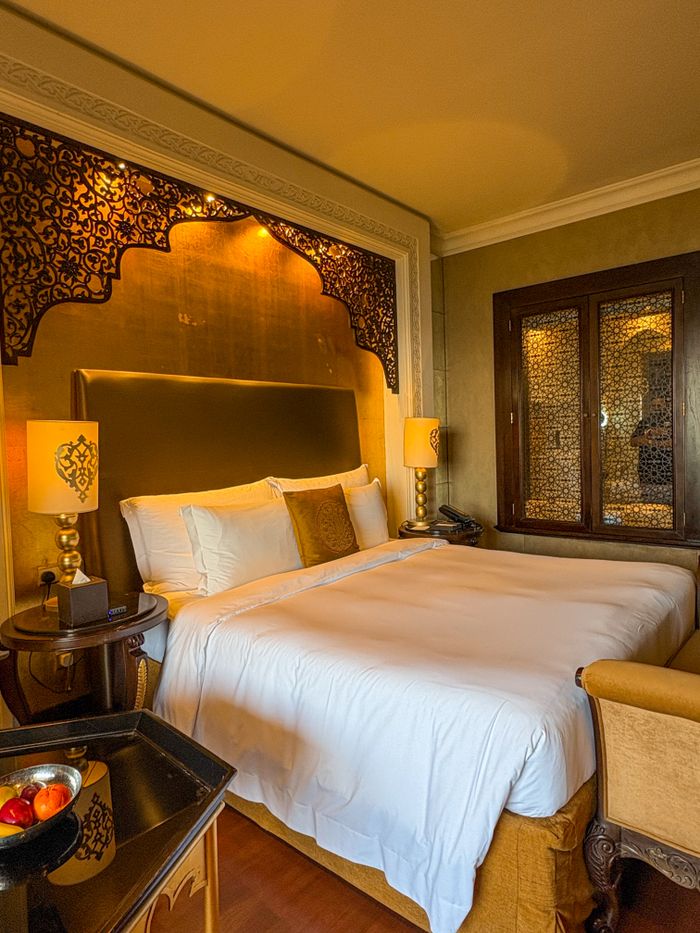 Elegant hotel room with ornate decor and plush bedding