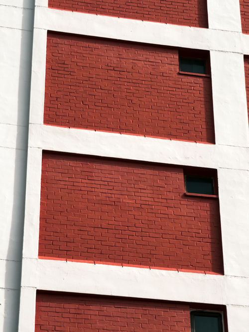 Free Detailed view of a red brick building facade with minimal windows, geometric design. Stock Photo