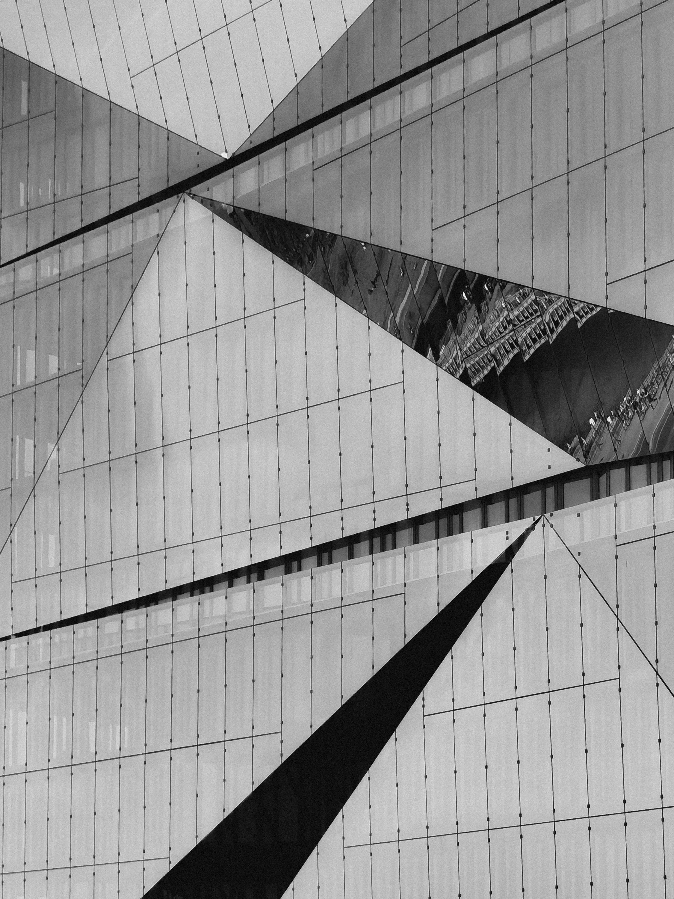 Black and white abstract capture of architectural geometric facade with reflections.