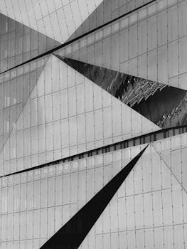 Black and white abstract capture of architectural geometric facade with reflections.