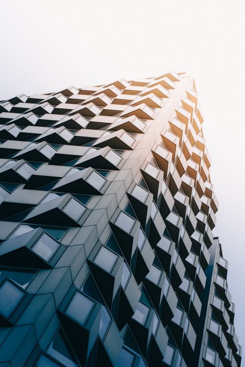 Modern High-Rise Building with Geometric Facade · Free Stock Photo